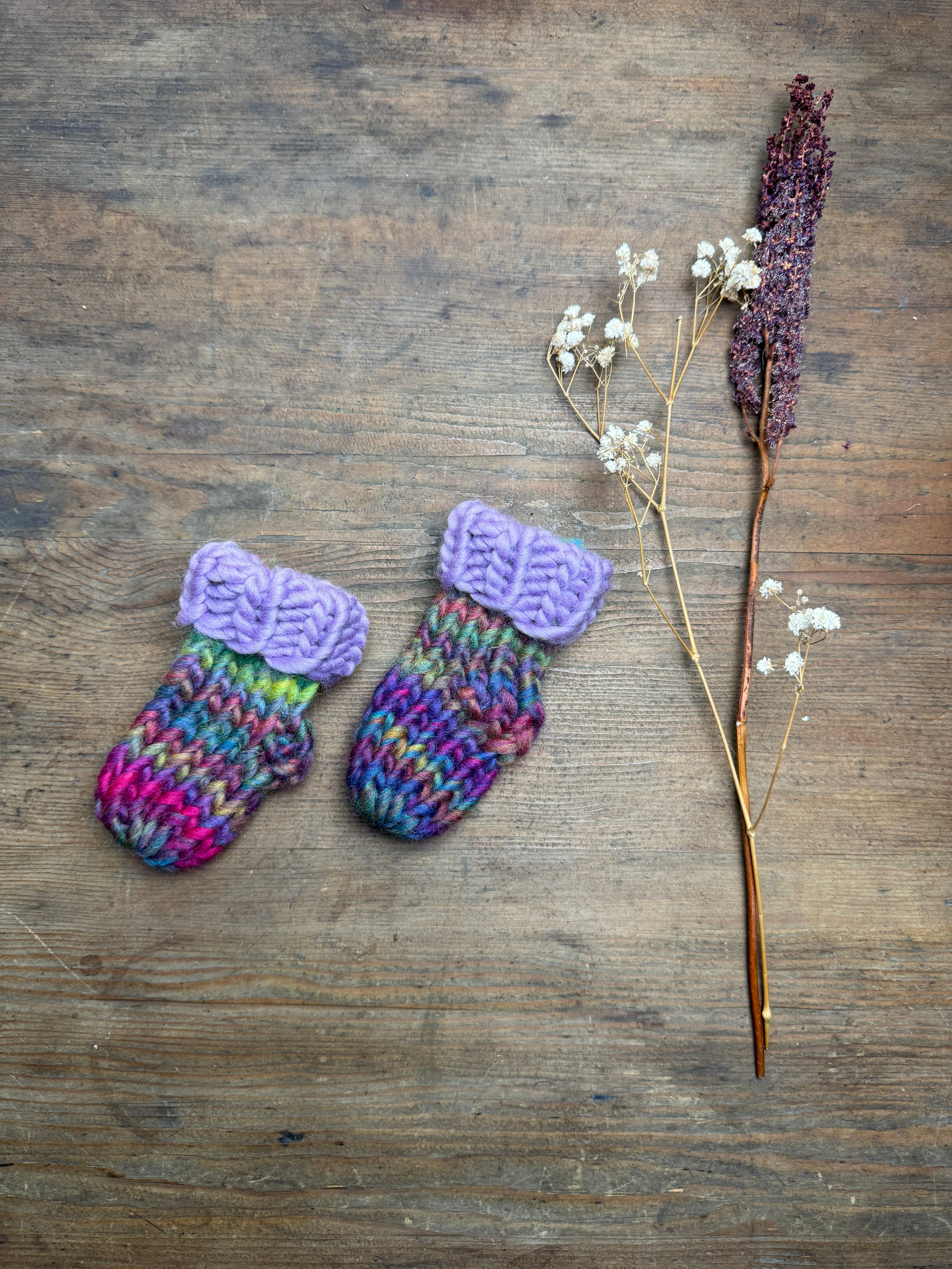 Newborn knitted socks in lilac and rainbow