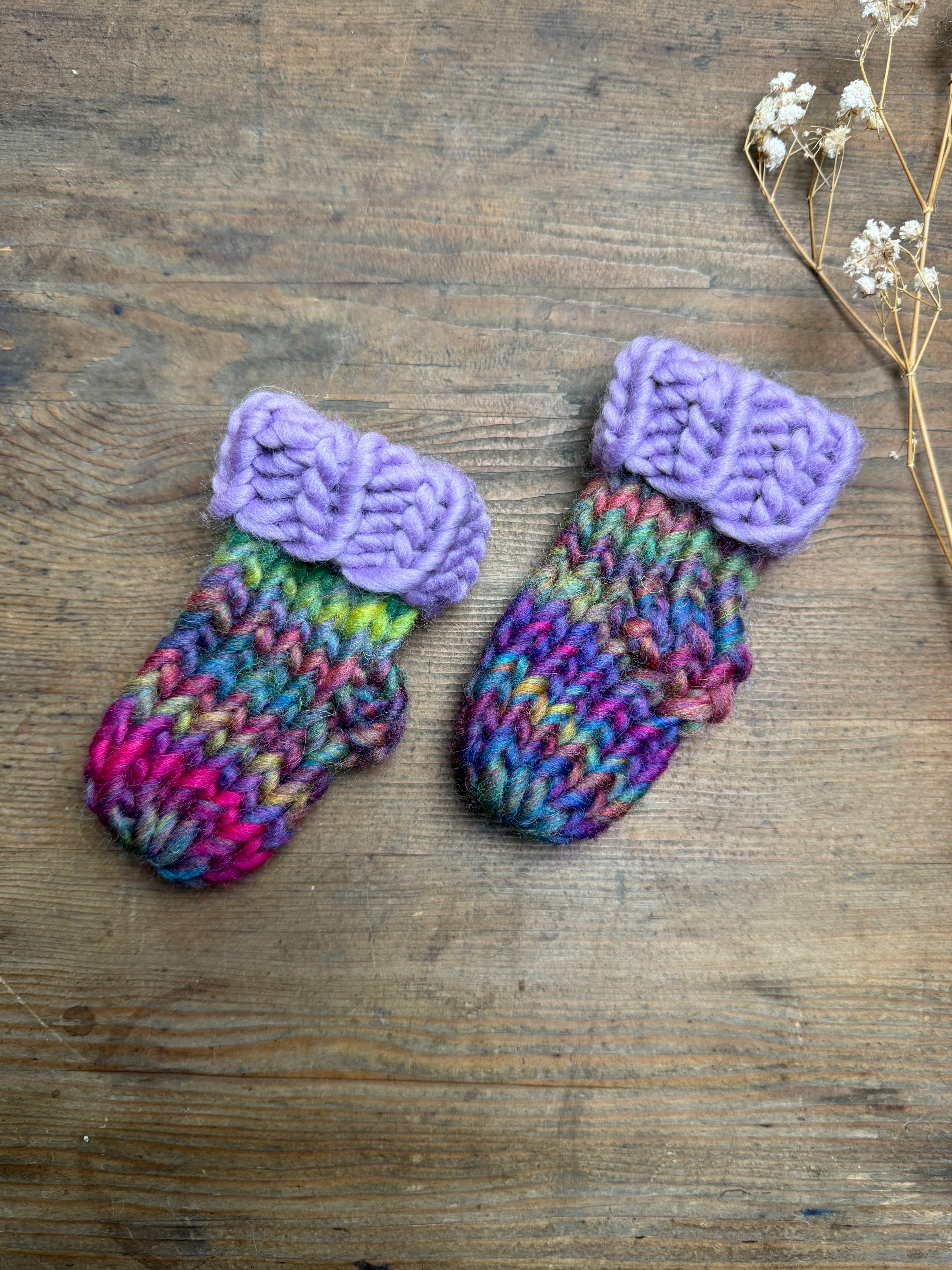 Newborn knitted socks in lilac and rainbow